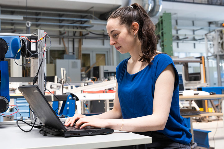 A woman sits in front of a computer